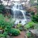 A waterfall in a lush garden setting